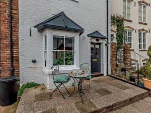 Beautiful 2 Bedroom Riverside Cottage في بريدغنورث: فناء به طاولة وكراسي أمام المنزل