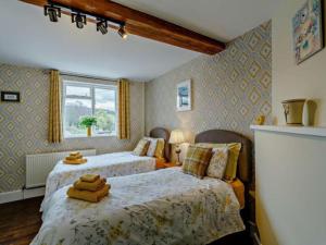 a bedroom with two beds and a window at Beautiful 2 Bedroom Riverside Cottage in Bridgnorth