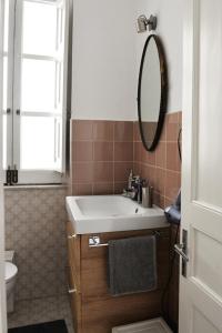 a bathroom with a sink and a mirror at Central Apartment with Panoramic Terrace in Catania
