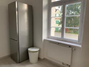 a bathroom with a refrigerator and a window at Apartment on the ground floor in Gutenzell-Hürbel