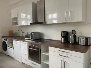 a kitchen with white cabinets and a counter top at Apartment on the ground floor in Gutenzell-Hürbel