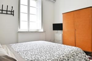 a bedroom with a bed and a dresser and a window at Central Apartment with Panoramic Terrace in Catania