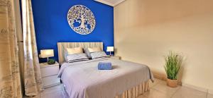 een slaapkamer met een bed en een blauwe muur bij Ferienwohnung Jandia Dream in Morro del Jable