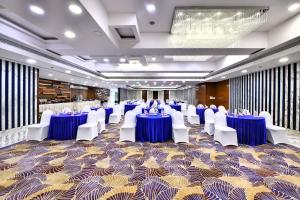 um salão de banquetes com mesas azuis e cadeiras brancas em The Fern Residency, Subhash Bridge, Ahmedabad em Ahmedabad