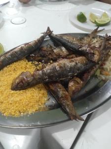 un plato de comida con pescado encima del arroz en Casa e cachoeira, en Pedro de Toledo