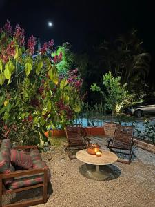 - une terrasse avec une table, des chaises et des fleurs dans l'établissement Vila Adega Maravilha, à São Roque