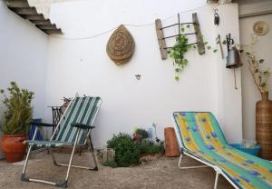 dos sillas sentadas junto a una pared con plantas en Casa rural La Luna, 