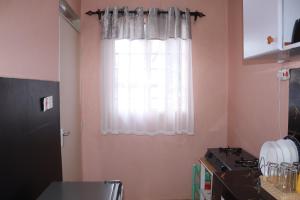 cocina con ventana, fregadero y encimera en Cozy 1 bedroom apartment in Claycity, Kasarani, en Nairobi