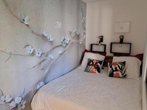 Séduisant studio avec cour privative في لا كراو: غرفة نوم مع سرير مع زهور على الحائط