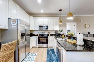 a kitchen with white cabinets and a stainless steel refrigerator at 'Cuse-stal in Myrtle Beach