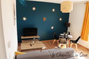 sala de estar con sofá y pared azul en La Chapelle du Quai, en Dunkerque
