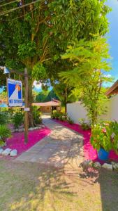 a walkway with pink flowers in front of a building at Pousada Meu Sossego in Barra Grande