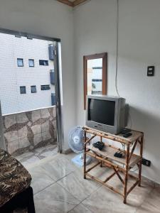 een televisie op een tafel in een kamer bij kitnet Guilhermina PG in Praia Grande