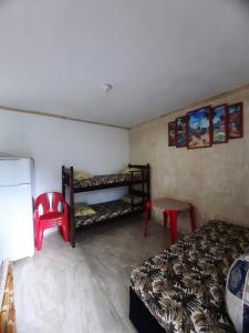 een kamer met een bed, een tafel en een stoel bij kitnet Guilhermina PG in Praia Grande