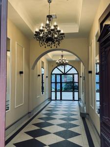 an empty hallway with a chandelier and a hallway with a door at URBAN Penthouse FREE parking i rowery in Poznań