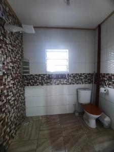 een badkamer met een toilet en een raam bij kitnet Guilhermina PG in Praia Grande