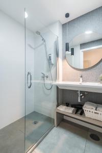 ein Bad mit einer Dusche, einem Waschbecken und einem Spiegel in der Unterkunft Smartr Las Palmas in Las Palmas de Gran Canaria