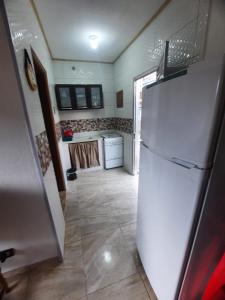 een keuken met een witte koelkast in de kamer bij kitnet Guilhermina PG in Praia Grande