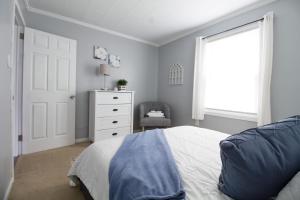 ein Schlafzimmer mit einem Bett, einer Kommode und einem Fenster in der Unterkunft The Sanctuary Company Johnson City in Bristol