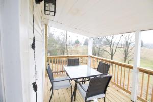 eine Veranda mit einem Tisch und Stühlen darauf in der Unterkunft The Sanctuary Company Johnson City in Bristol