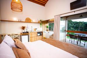 um quarto com uma cama e uma cozinha com uma mesa em Chalés Quinta da Boa Vista em São Bento do Sapucaí