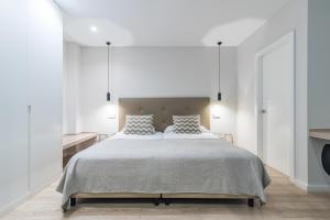 a white bedroom with a large bed with two pillows at Smartr Las Palmas in Las Palmas de Gran Canaria +20 photos