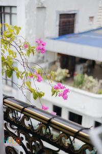 a bunch of pink flowers on a balcony at HoLo Central Hanoi - Serviced HomeStay in Hanoi