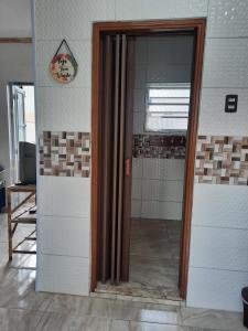 een glazen deur in een kamer met een spiegel bij kitnet Guilhermina PG in Praia Grande