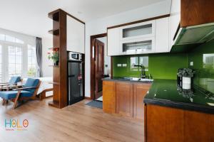 a kitchen with green walls and a counter top at HoLo Central Hanoi - Serviced HomeStay in Hanoi