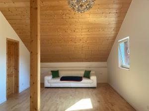 Sofá blanco en una habitación con techo de madera en Tu Casa Chiemsee en Gstadt am Chiemsee