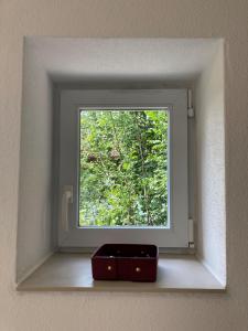 une fenêtre dans un mur avec une boîte devant elle dans l'établissement Tu Casa Chiemsee, à Gstadt am Chiemsee