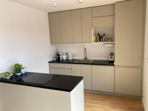 a kitchen with white cabinets and a black counter top at Tu Casa Chiemsee in Gstadt am Chiemsee