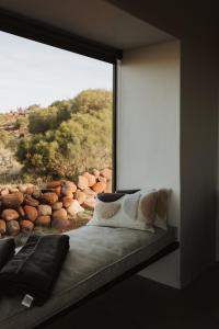 - une chambre avec une grande fenêtre donnant sur une colline dans l'établissement Spionkop Eco Cabin, 