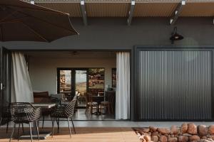 a dining room with a table and chairs and a patio at Spionkop Eco Cabin in Reddersburg