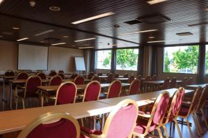 a conference room with tables and chairs and windows at Hotel Sommelo in Kouvola
