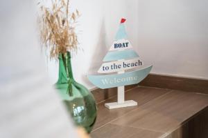 a boat to the beach welcome sign next to two vases at Romaní del Montgrí in L'Estartit