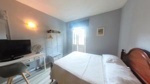 - une chambre avec un lit et un bureau avec une télévision dans l'établissement Funchal 19, à Funchal