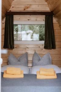 ein Schlafzimmer mit einem Bett mit zwei Kissen und einem Fenster in der Unterkunft Bed and Breakfast - Das Schutzhaus - Dein Basislager im Salzkammergut in Bad Aussee