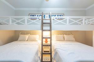 two beds in a room with two bunk beds at The Bluebird OBA at Phoenix West II in Orange Beach