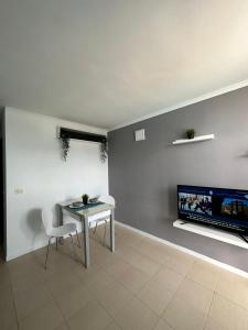 Una sala de estar con una mesa y un televisor. en Golf del Sur Tenerife - Casa Barrera verde green park la corbeta, en San Miguel de Abona 11 fotos más