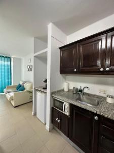 a kitchen with a sink and a living room at Golf del Sur Tenerife - Casa Barrera verde green park la corbeta in San Miguel de Abona +11 photos
