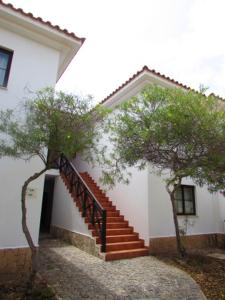 a staircase leading to a white building with trees at Tortuga Beach Village Private Apartments and Villas for Rent in Santa Maria