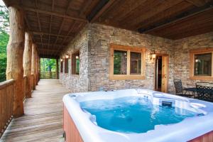 a jacuzzi tub in a house with a deck at Big Bear Ridge Lodge - Breathtaking mountain views and private forest scenes in amazing large log cabin in Gatlinburg