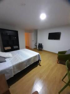 a bedroom with a bed and a flat screen tv at Excelente ubicación San Isidro Suite 11 in Lima