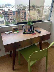 a wooden desk with a chair and a window at Excelente ubicación San Isidro Suite 11 in Lima