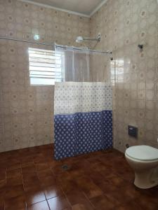 uma casa de banho com um chuveiro e um WC. em Casa no Centro 600m da Praia em Bertioga