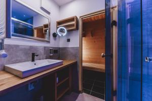 ein Bad mit einem Waschbecken und einer Dusche in der Unterkunft Apartment Margarethenstein in Kaprun