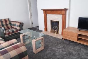 a living room with a fireplace and a couch and a table at Relax near Wollaton Park in Nottingham