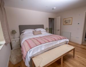a bedroom with a bed with a red and white blanket at Isle of Skye luxury cottage near Portree in Kensaleyre