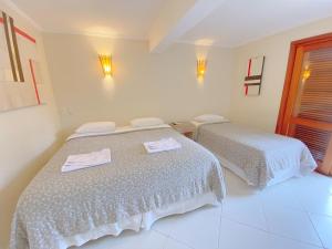 a bedroom with two beds with towels on them at Pousada Montemar in Ilhabela +38 photos